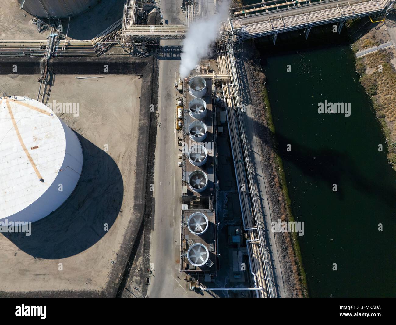 Aerial view of an industrial cooling tower bank with steam rising ...