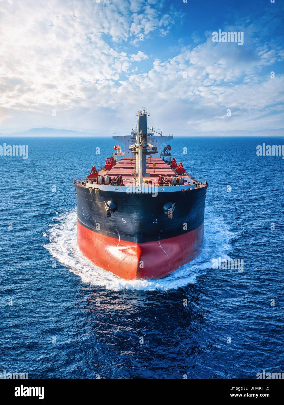 Close-up front view of a universal bulk carrier cargo ship traveling over blue ocean Stock Photo