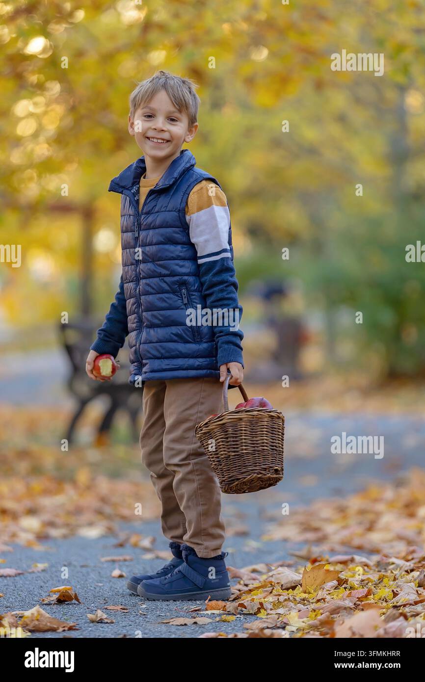 Cute little child, sweet boy in a park, sitting on a bench and in the ...