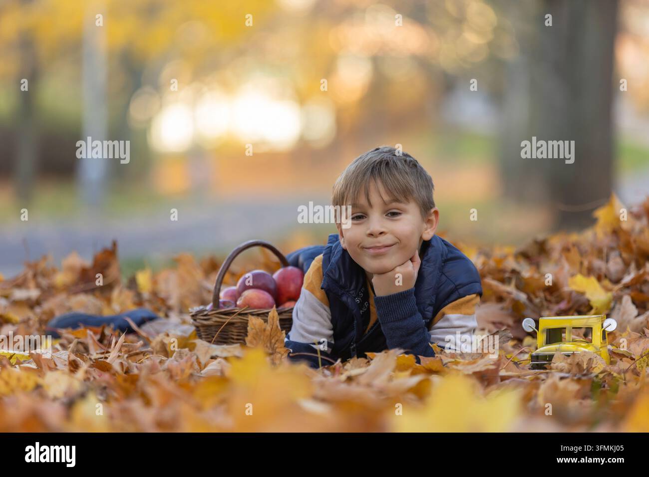 Cute little child, sweet boy in a park, sitting on a bench and in the ...