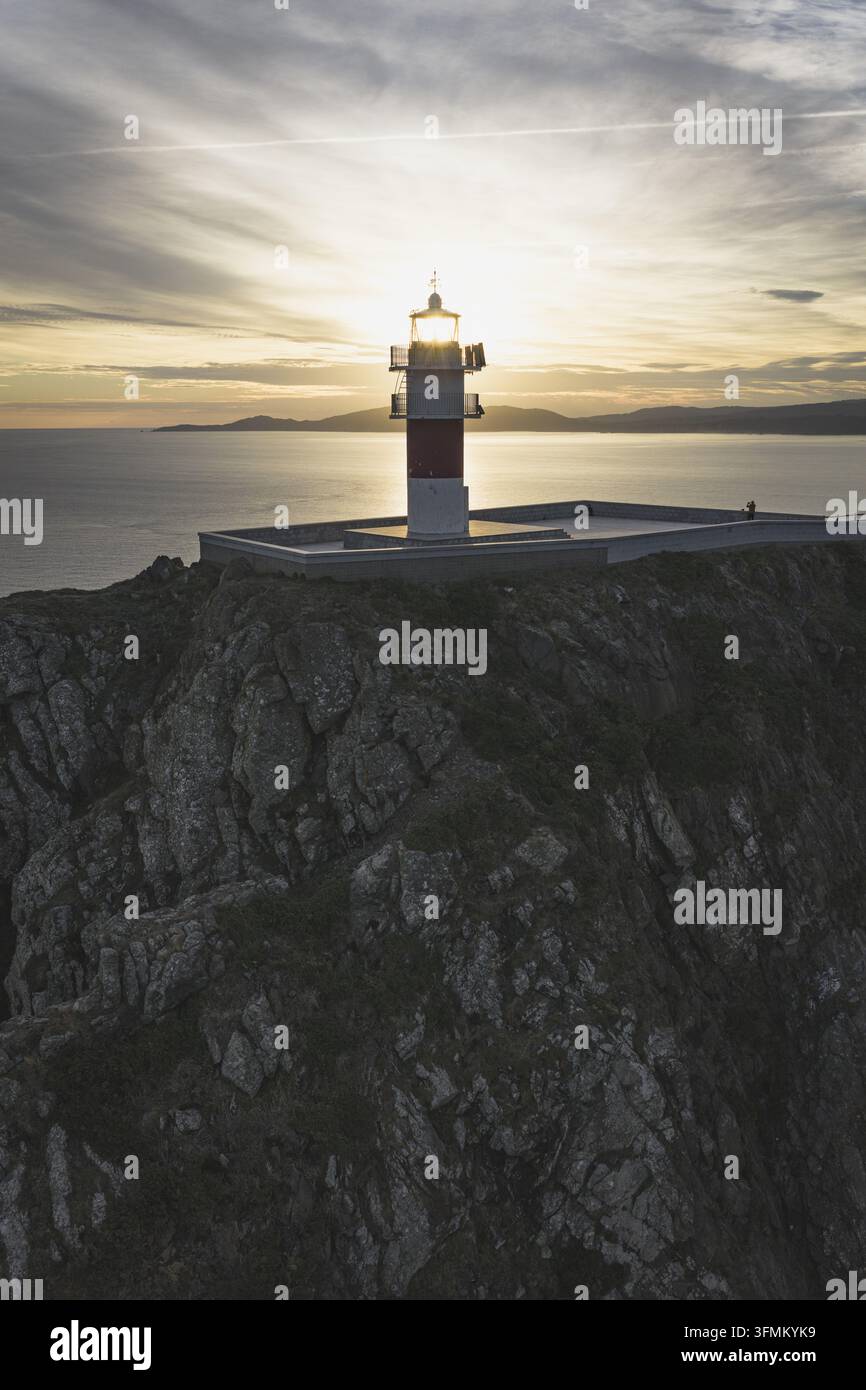 Aerial view of a lighthouse perched on a rugged rocky cliff overlooking ...