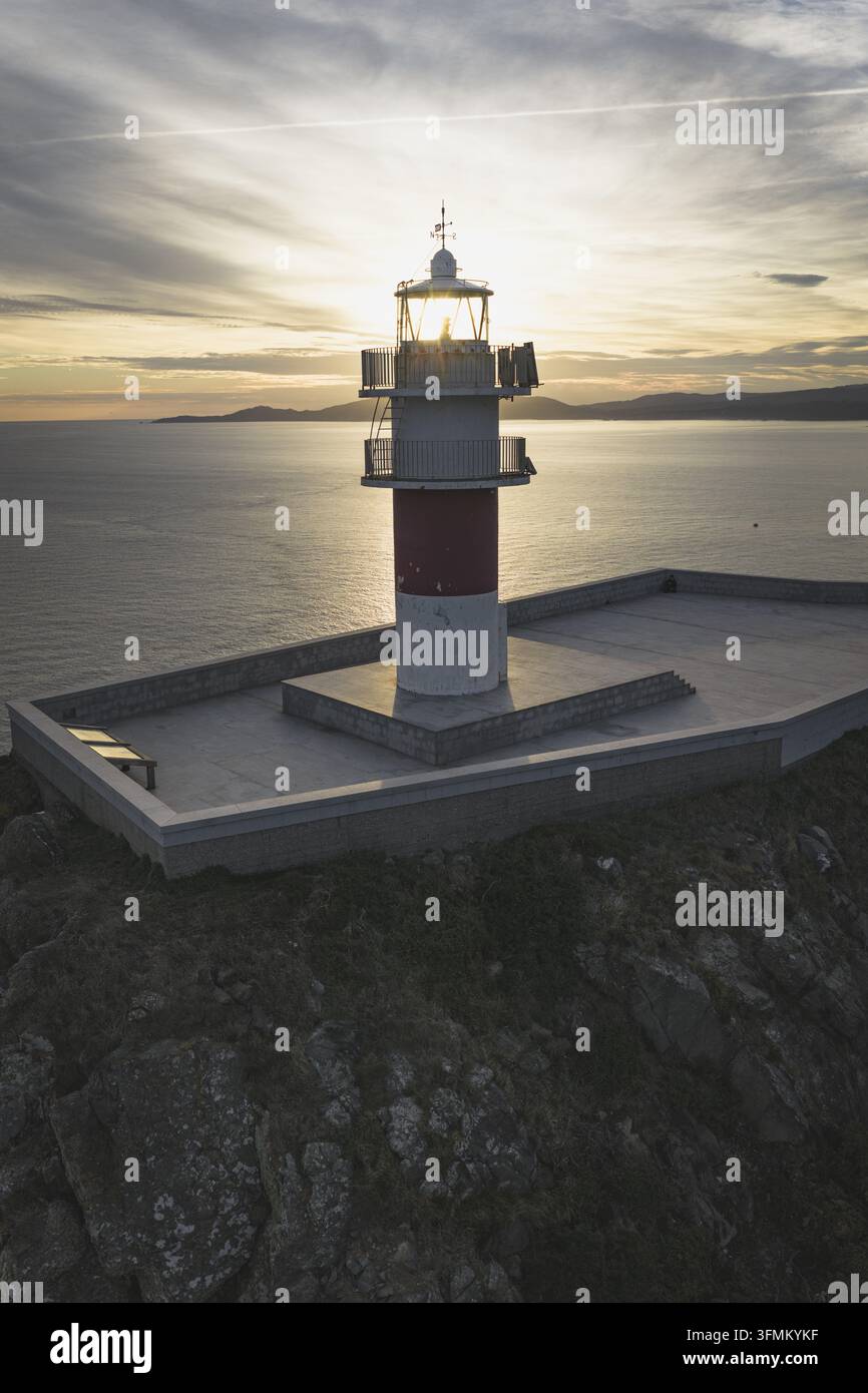 Aerial view of a lighthouse on a rocky cliff overlooking the ocean ...