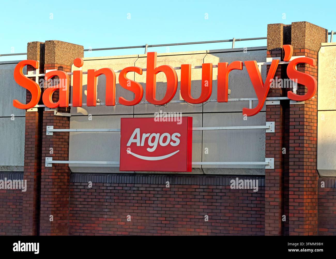 Argos concession branding beneath a Sainsbury’s supermarket sign, showing integration of the two retail brands. Stock Photo