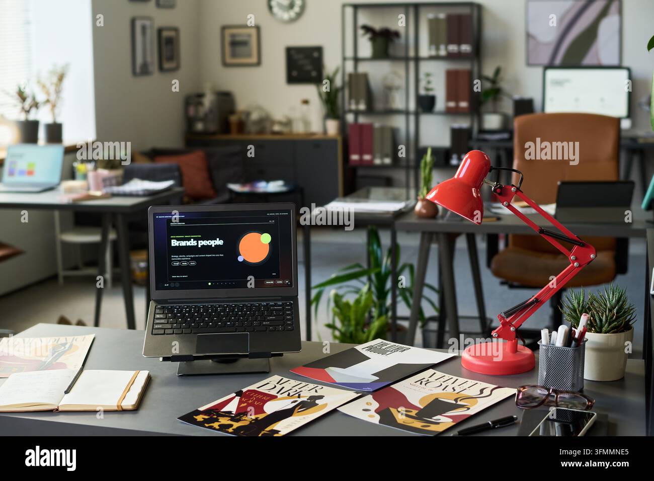 Creative Agency Workspace Featuring Laptop and Branding Projects Stock Photo