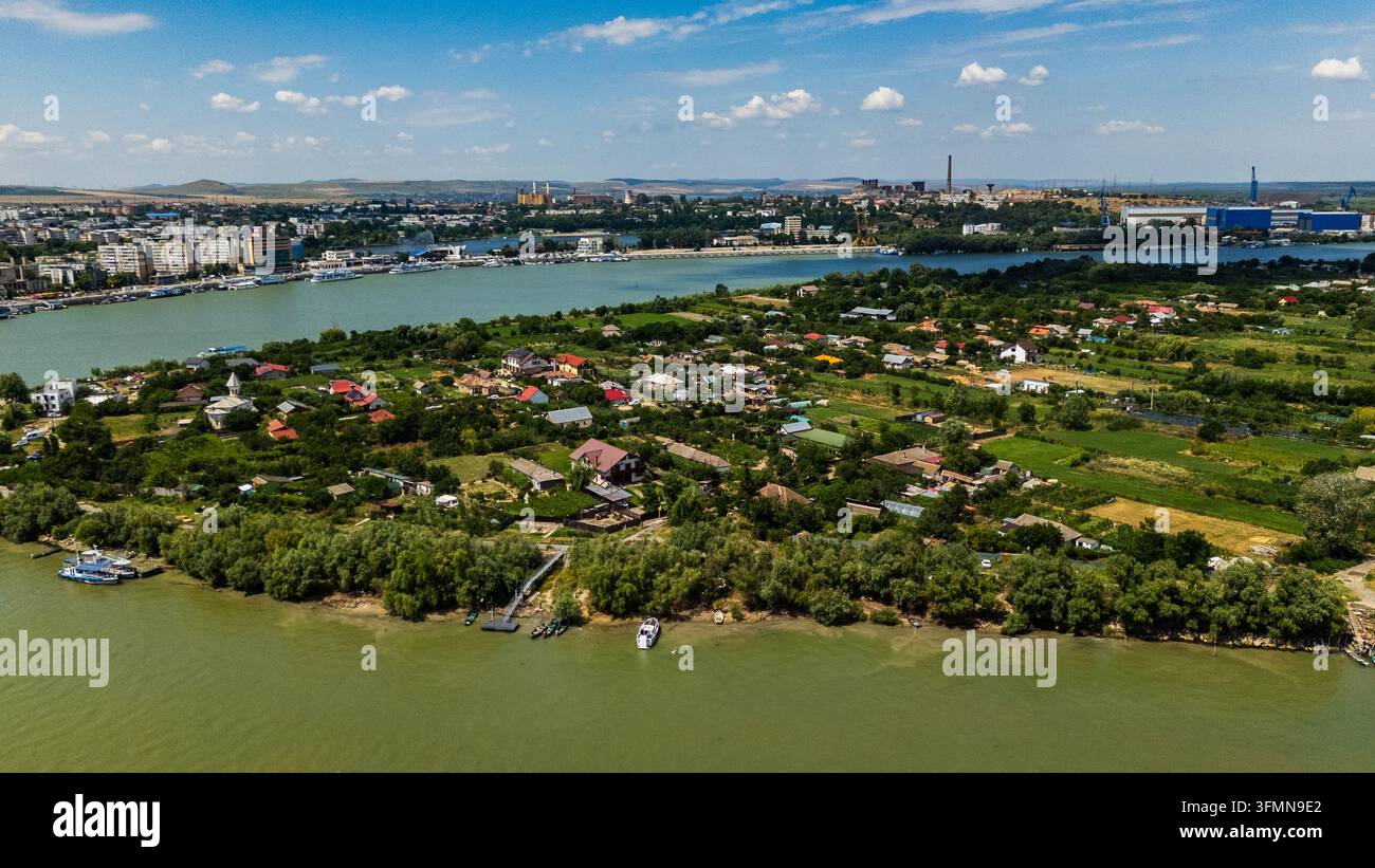 Aerial view of the Danube river and the town of Tulcea with lush green ...