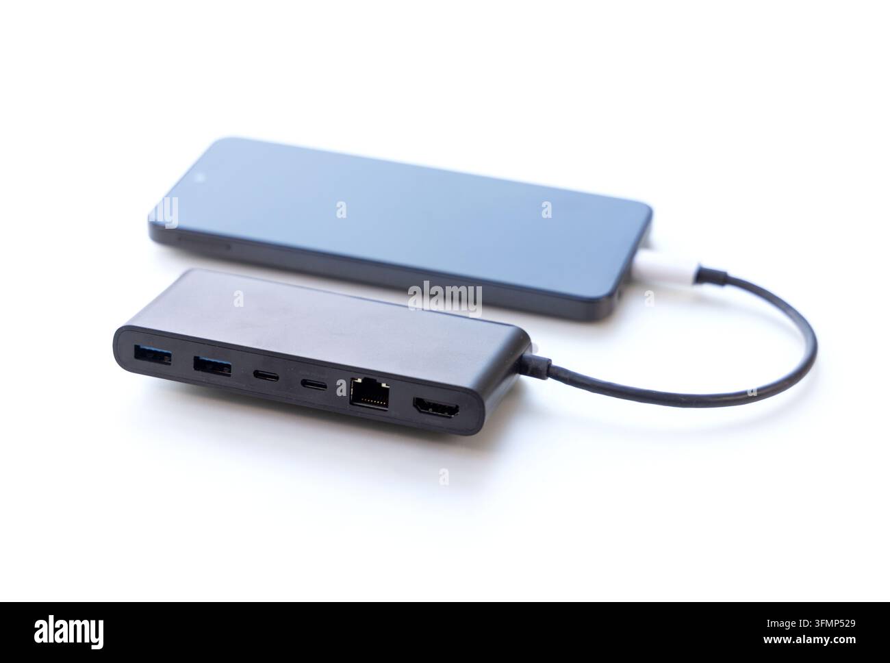 A dark multiport adapter connected via cable to a mobile phone Stock Photo