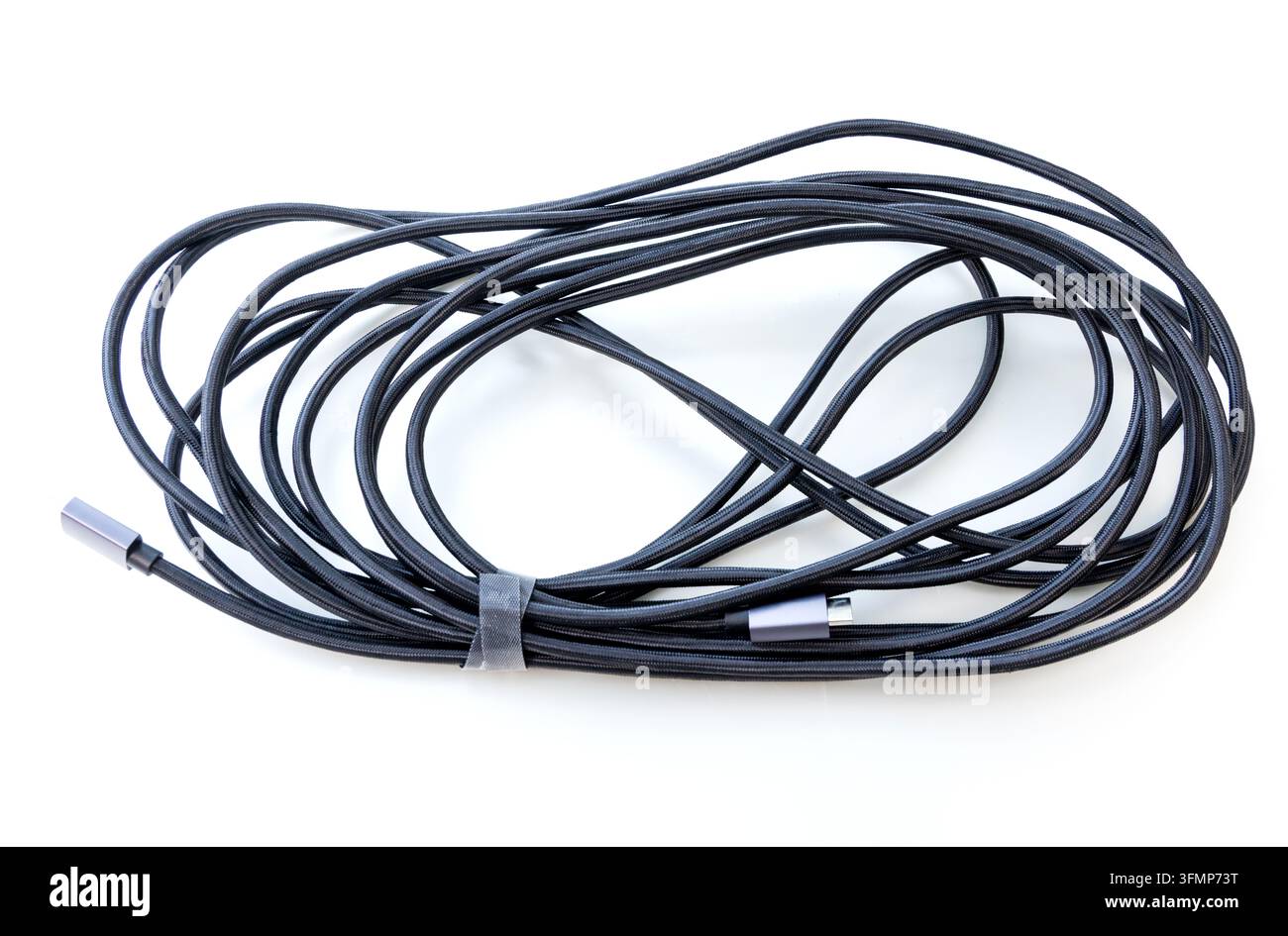 A long braided charging cord rests coiled on white background Stock Photo
