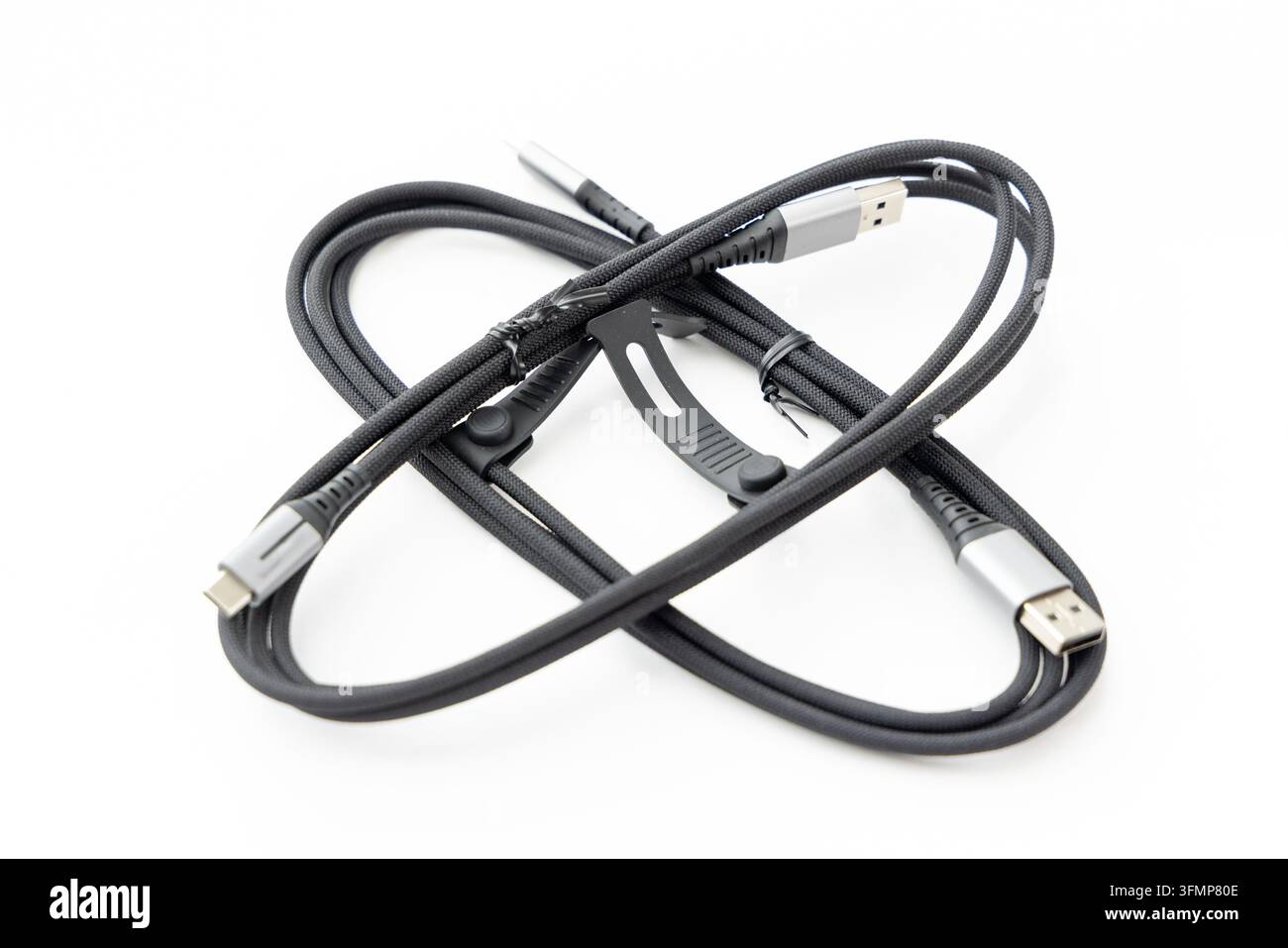 A coiled black braided USB cable sits on white background Stock Photo