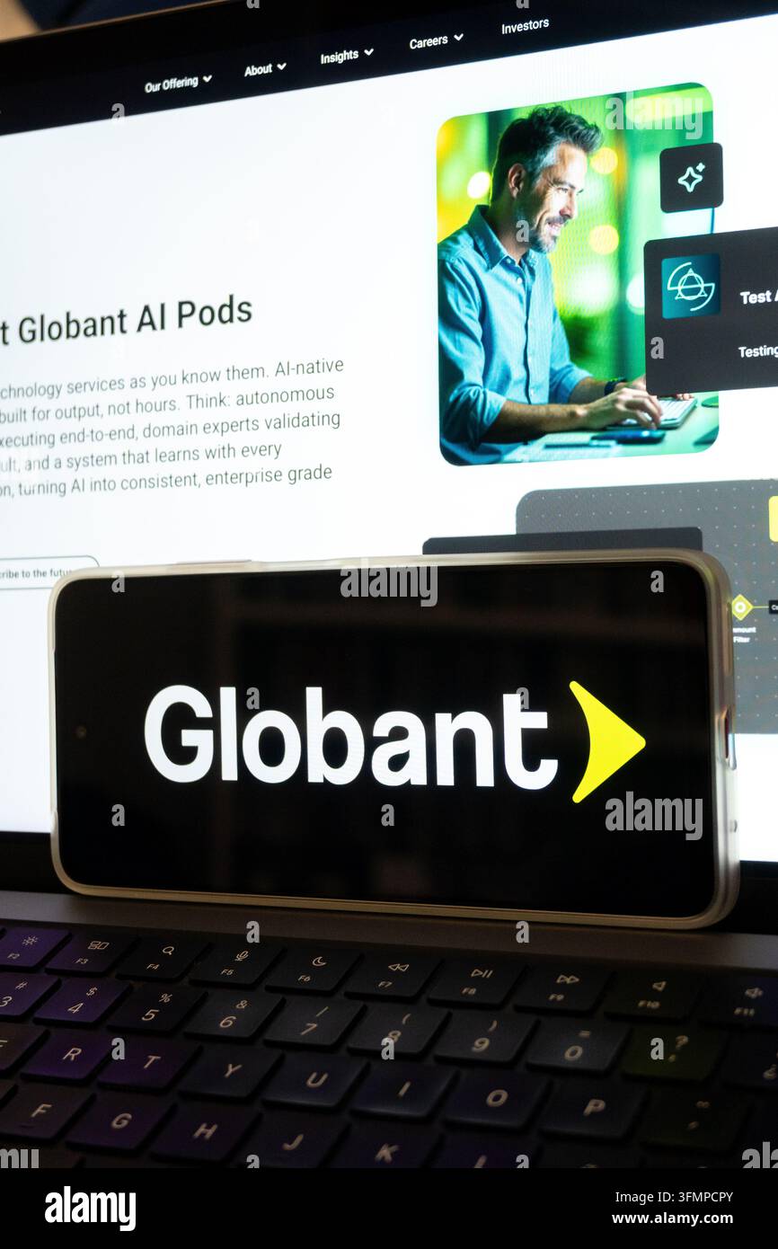Mexico city, mexico, 06 20 2026, smartphone showing globant logo over a laptop displaying the company's ai services website Stock Photo