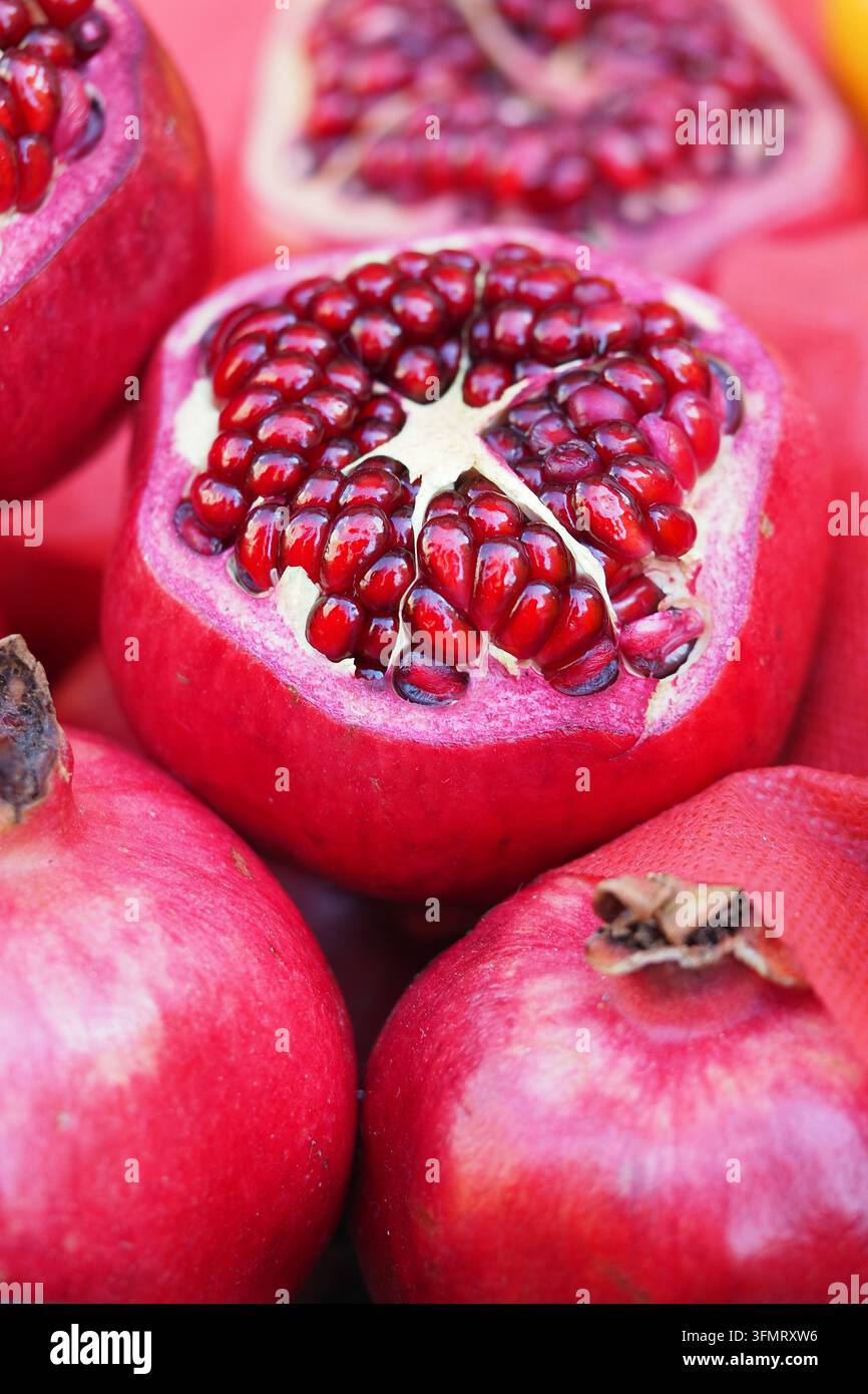 Fresh pomegranates displayed on a table at a market in autumn season Stock Photo