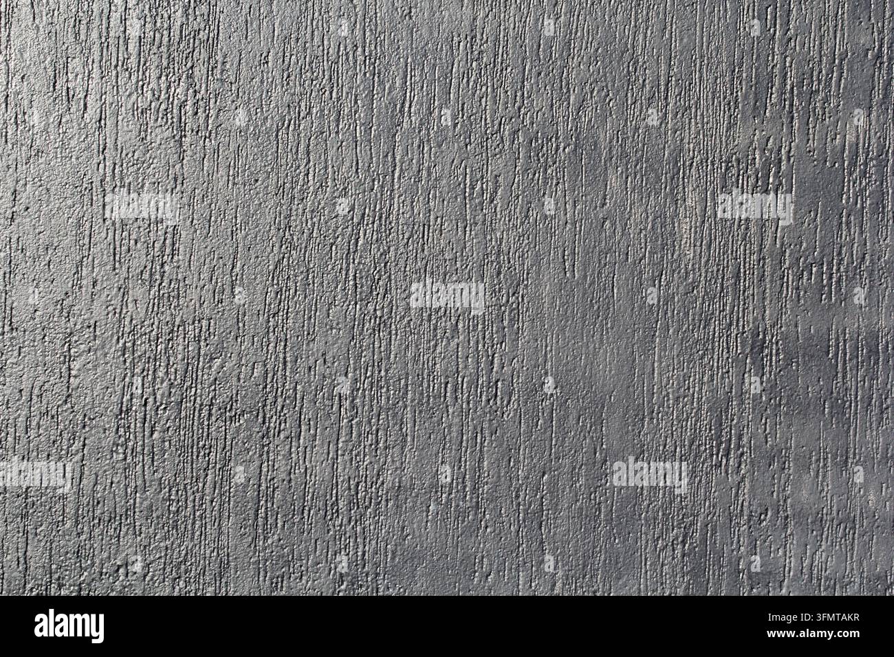 Grey textured plaster wall with a distressed, scratched vertical pattern Stock Photo