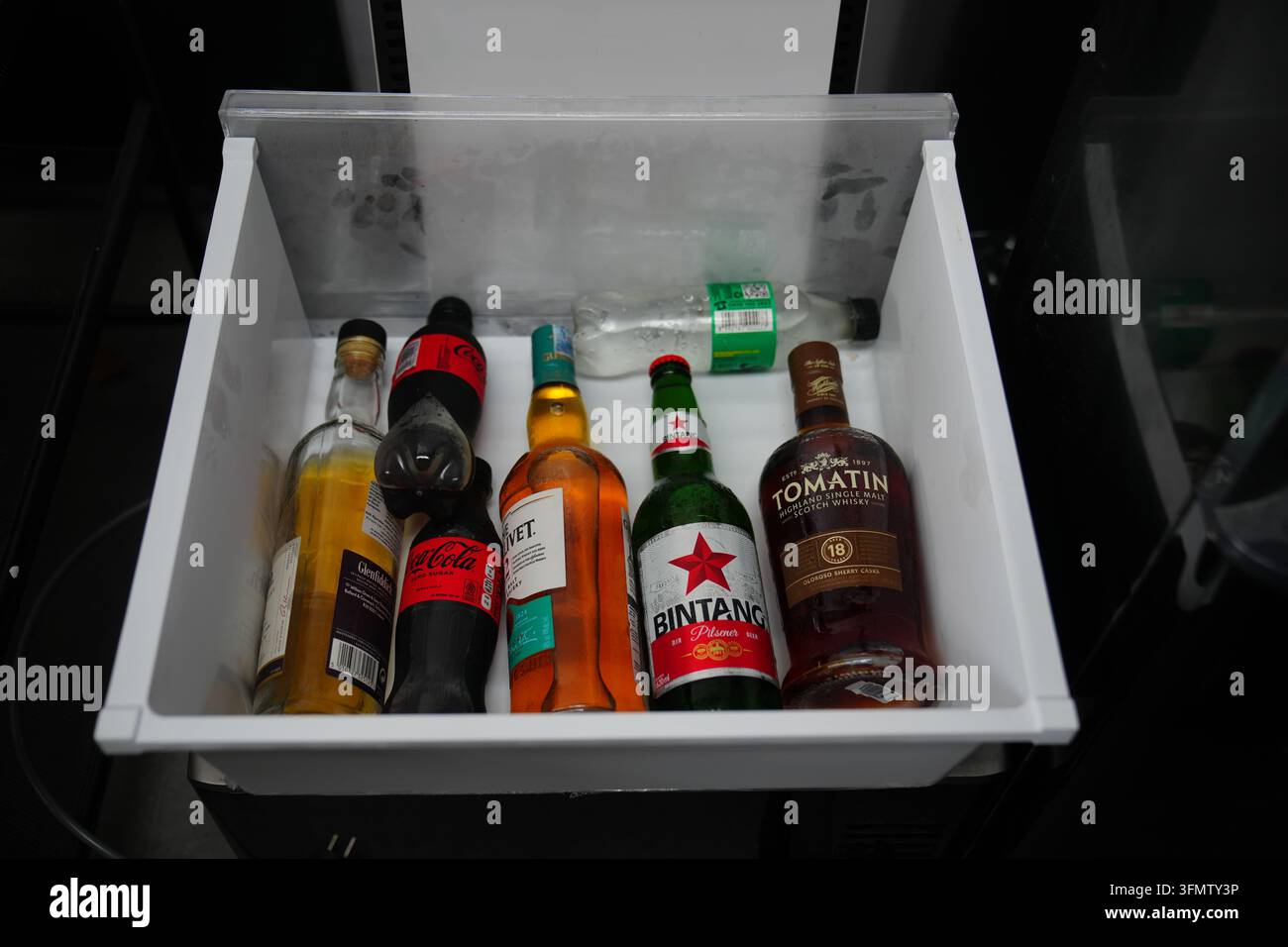 Bottles of alcoholic beverages are seen inside a refrigerator of a ...