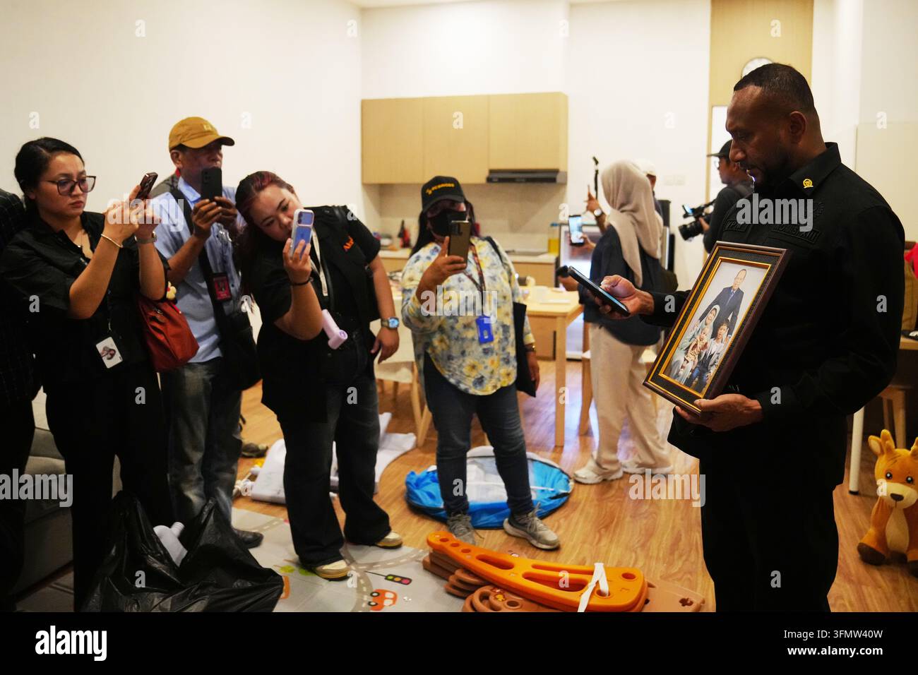 A lawmaker shows journalists a framed family photograph at a ...