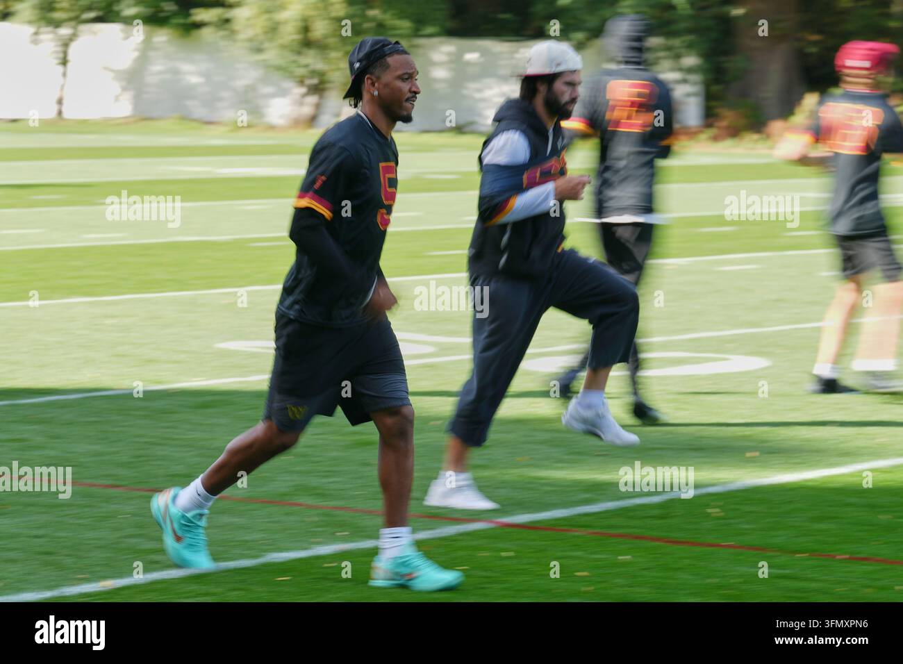 Commanders Vector Washington Commanders quarterback Jayden Daniels (5), left, takes part ...