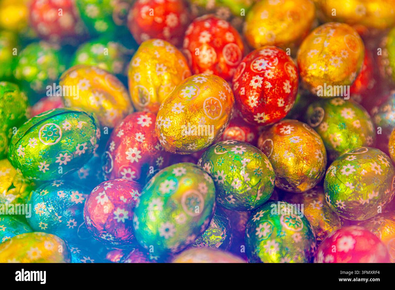 Colorful Easter Chocolate Eggs Wrapped in Shiny Foil with Floral Patterns Stock Photo