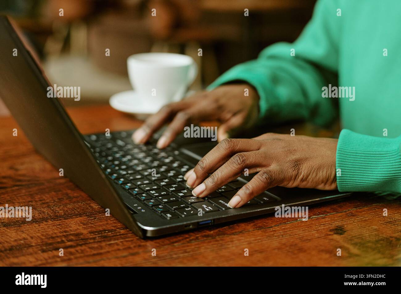 Hands of Black Woman Typing on Laptop Keyboard in Cafe Stock Photo