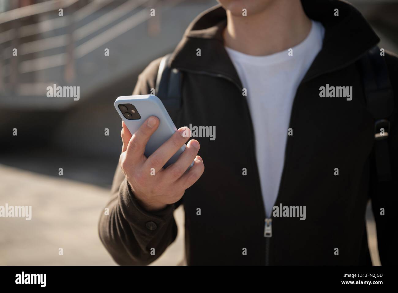 Man using smartphone outdoors in modern city Stock Photo