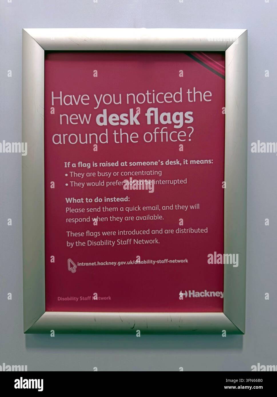 Hackney Council office notice explaining new desk flags used to support disability awareness and staff communication. Stock Photo