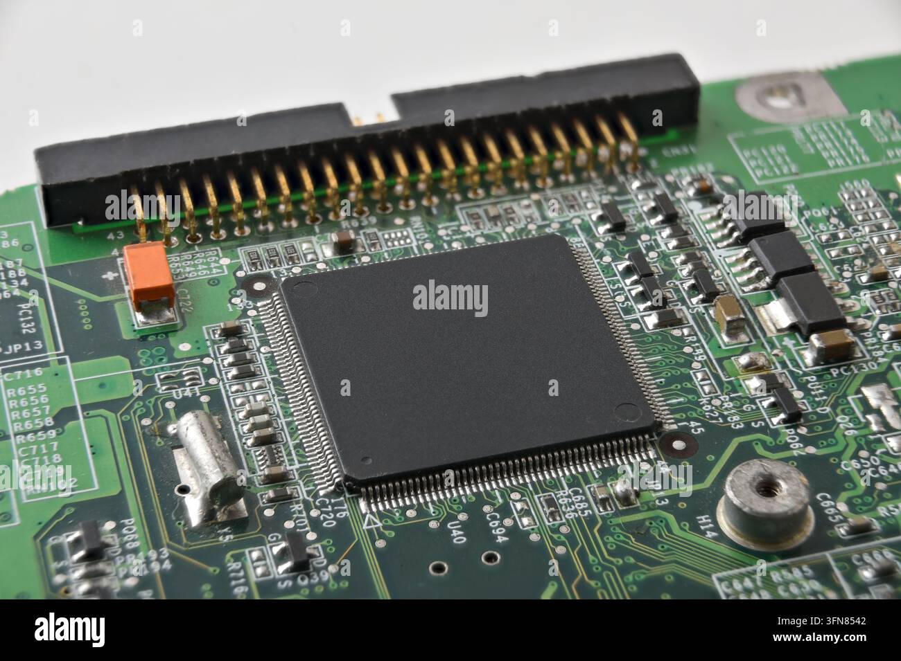 Detailed view of an embedded microcontroller on a green printed circuit board with connectors and surface-mounted components, illustrating industrial Stock Photo