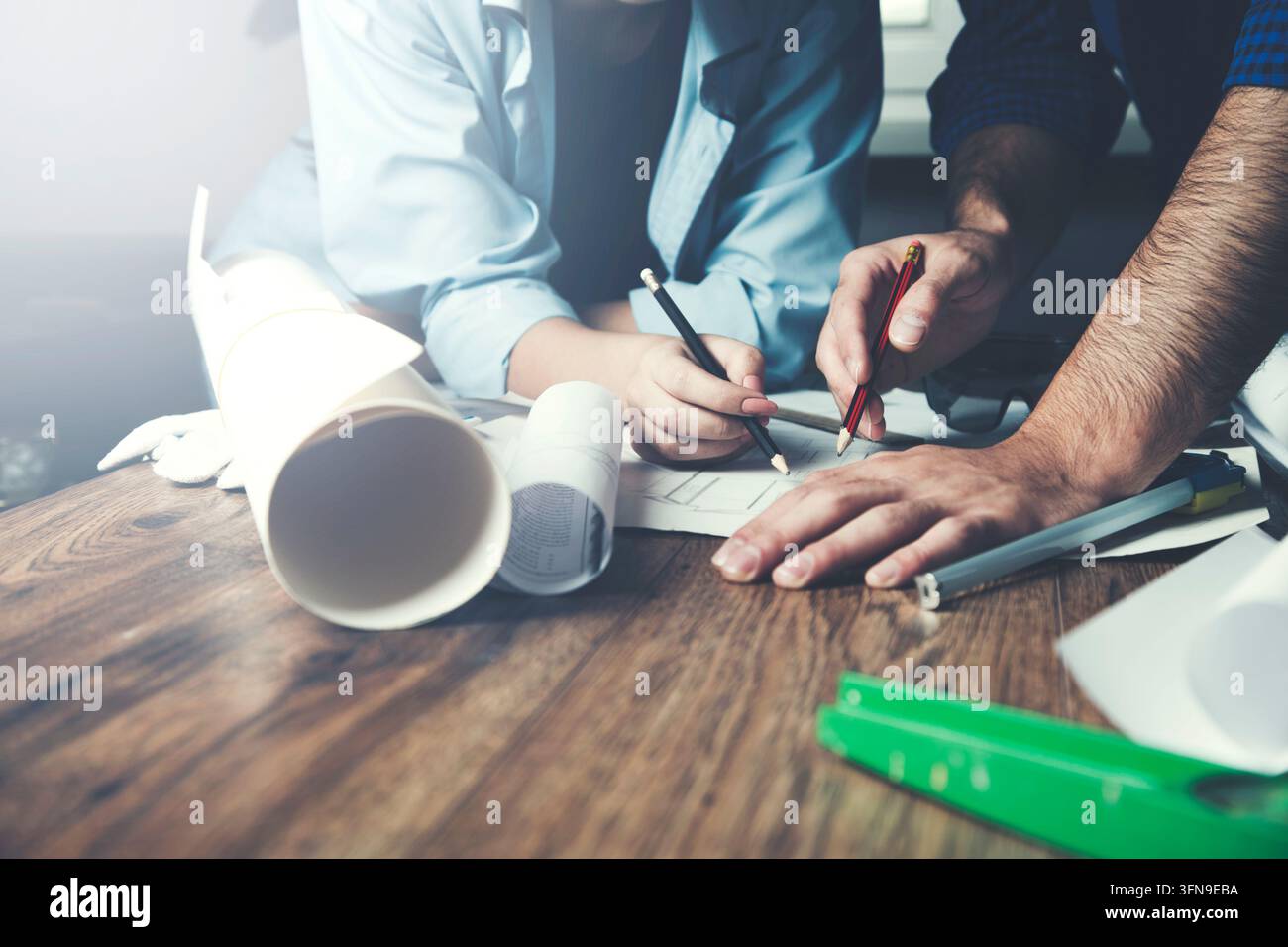 Team of architects working on construction plans Stock Photo