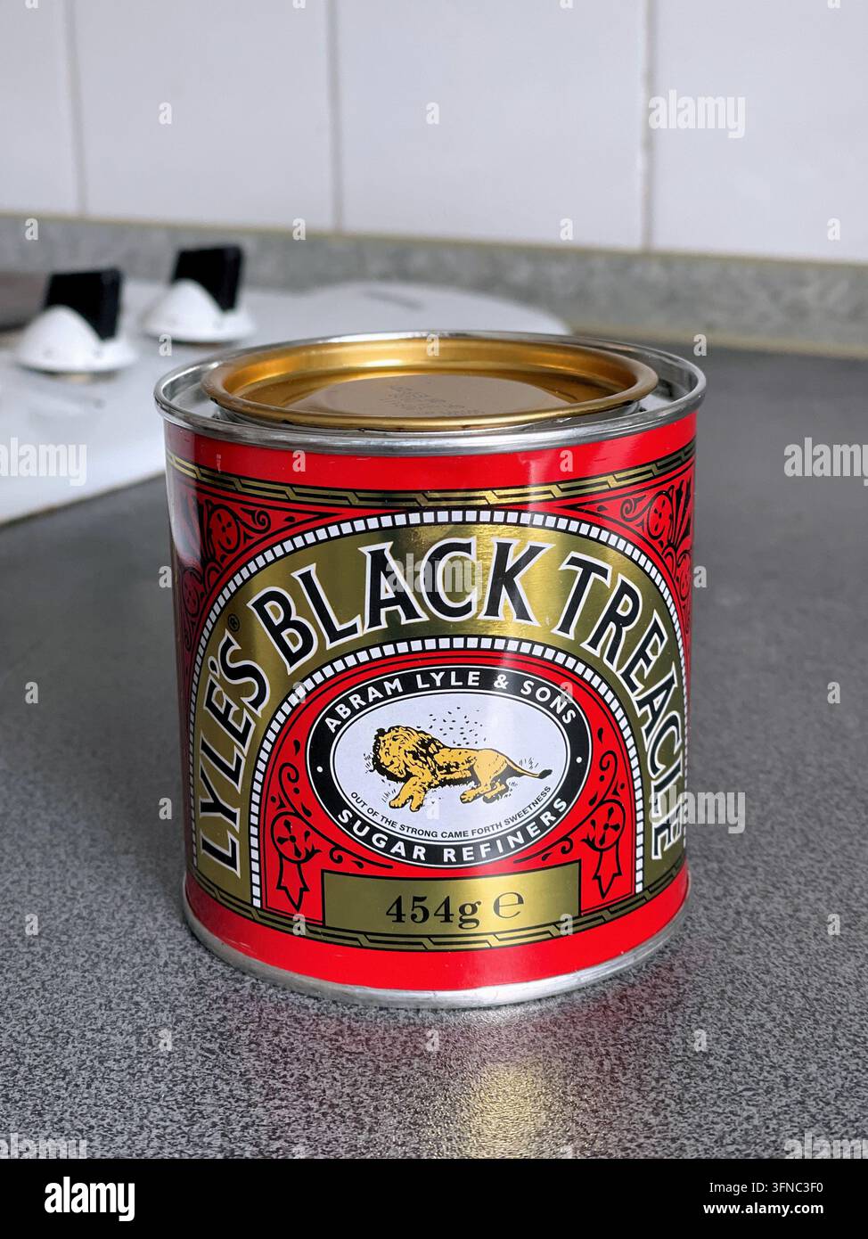 A tin of Lyle's Black Treacle on a kitchen counter, a common provision in British kitchens, UK - Smartphone Captured Stock Image