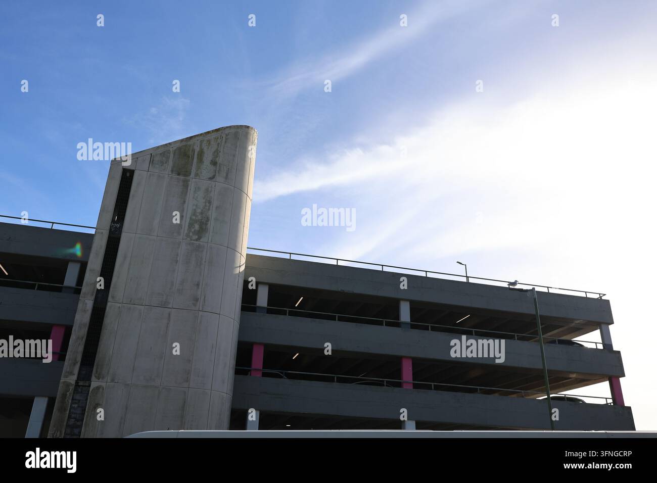 Concrete architectural structure beneath a dramatic blue and white sky. Stock Photo