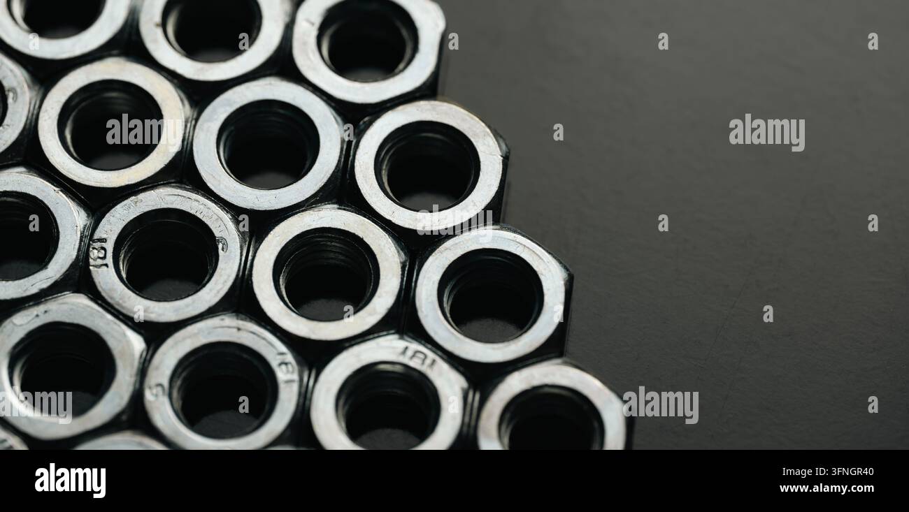 Steel nuts creating a honeycomb pattern, symbolizing connection and engineering Stock Photo