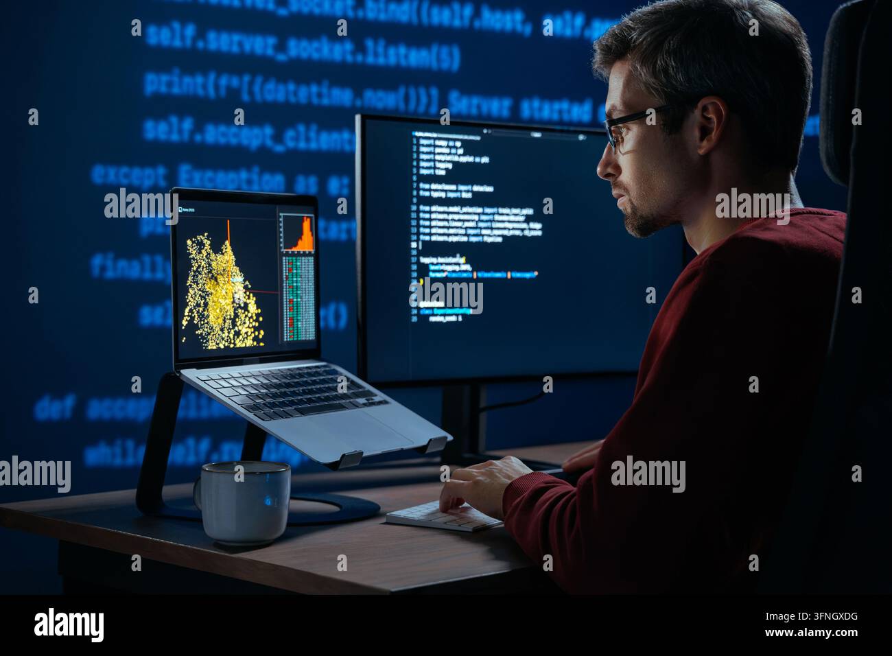 Developer sits in a dimly lit workspace, in front screens displaying code and data science data graph. Focused programmer working, deeply immersed in solving an artificial intelligence problem Stock Photo