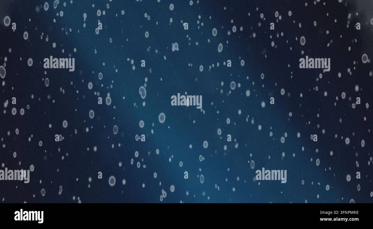 Abstract background featuring glowing particles and dust floating on a dark textured surface with subtle blue gradient lighting. Stock Photo
