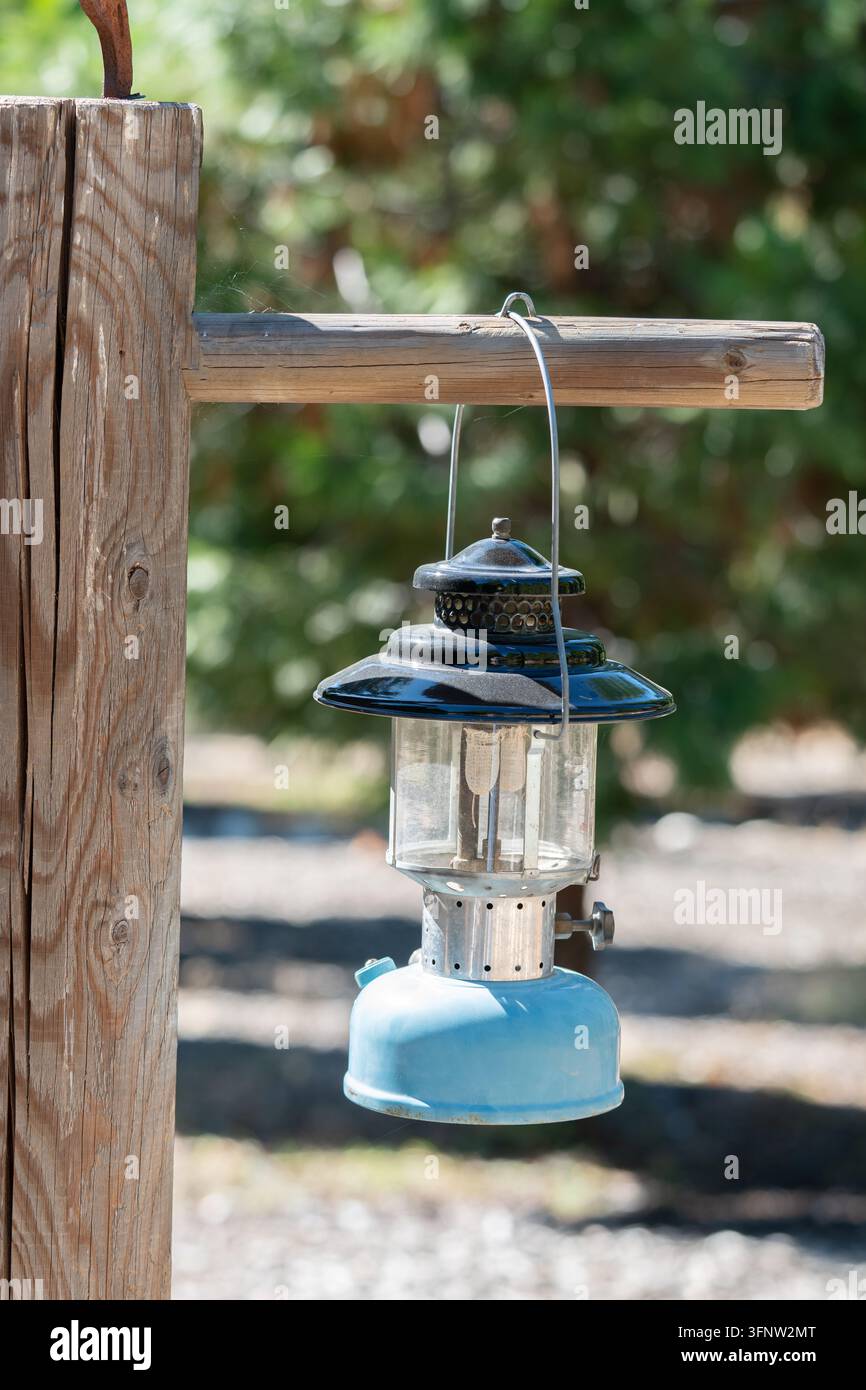 Vintage Blue Camping Lantern Hanging From Wooden Post Stock Photo
