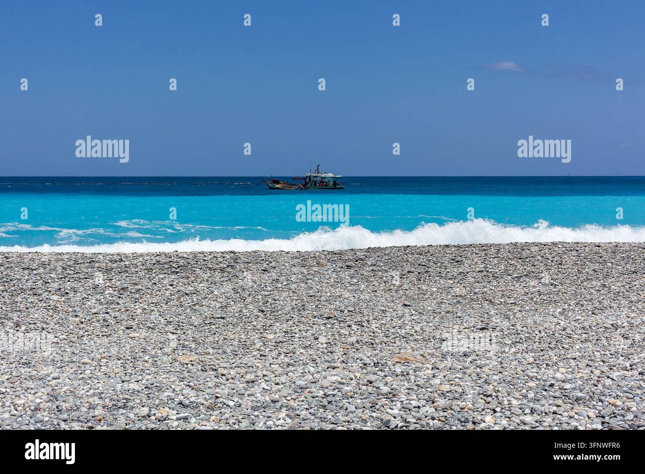 Pacific Ocean view from pebble beach in Hualien, Taiwan. Small fishing ...