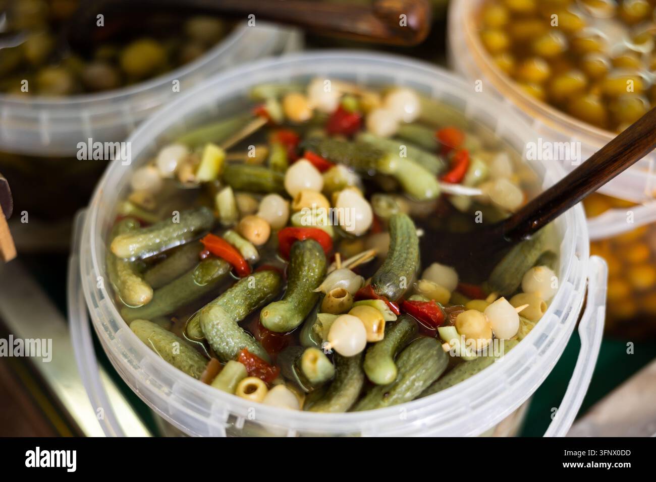 Plastic Container Processing Marinated green olives, onions, cucumbers, peppers in a plastic ...
