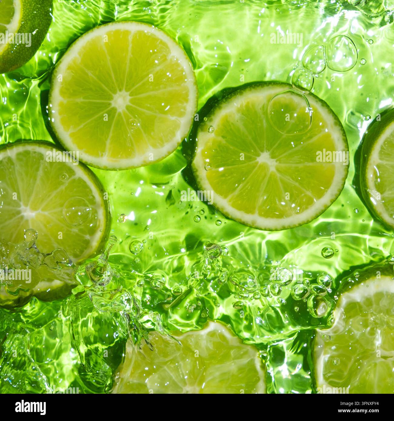 Fresh Lime Slices Floating in Clear Water, Top View Stock Photo