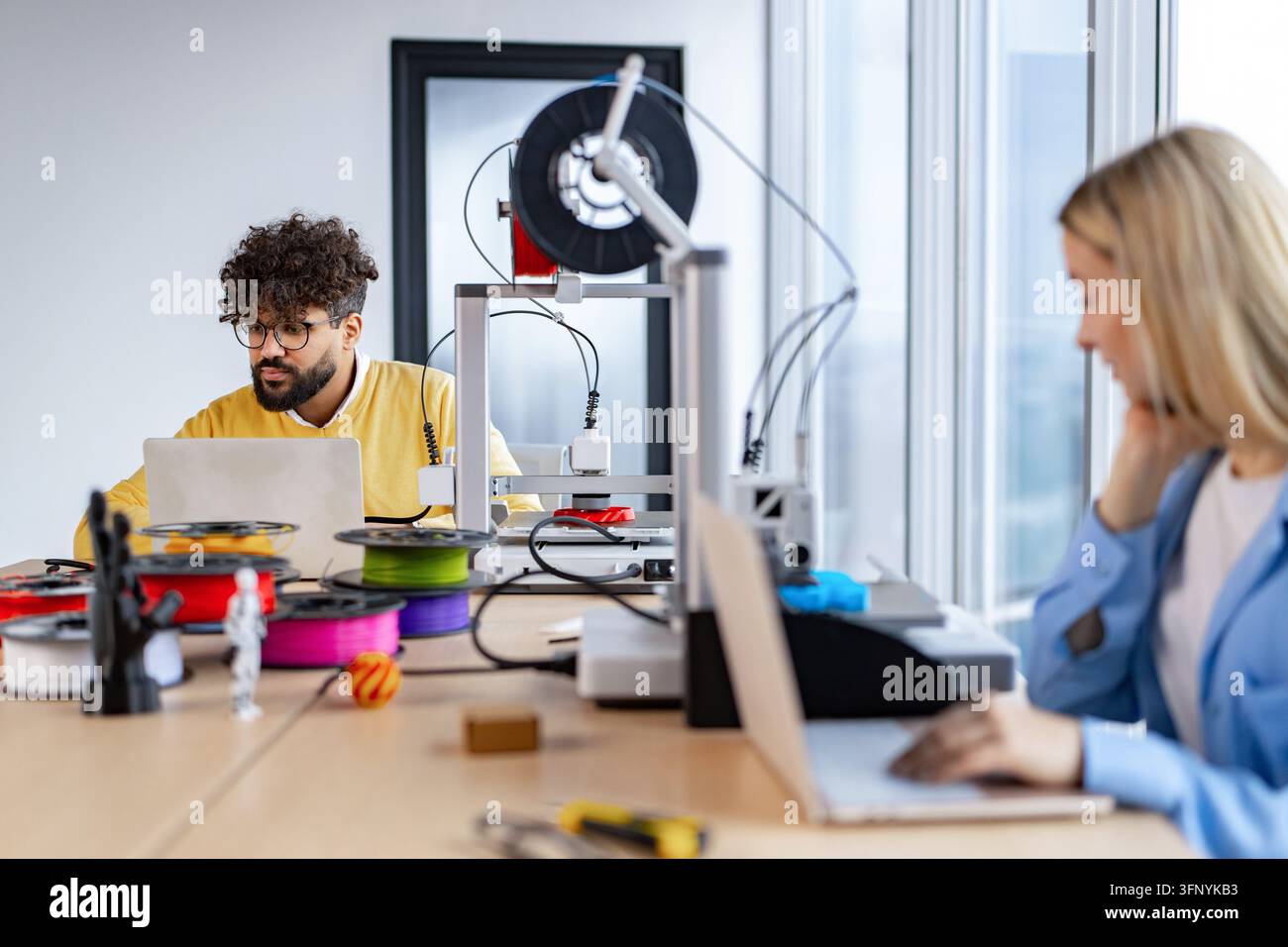 Two colleagues collaborate in a modern office space, utilizing 3D ...