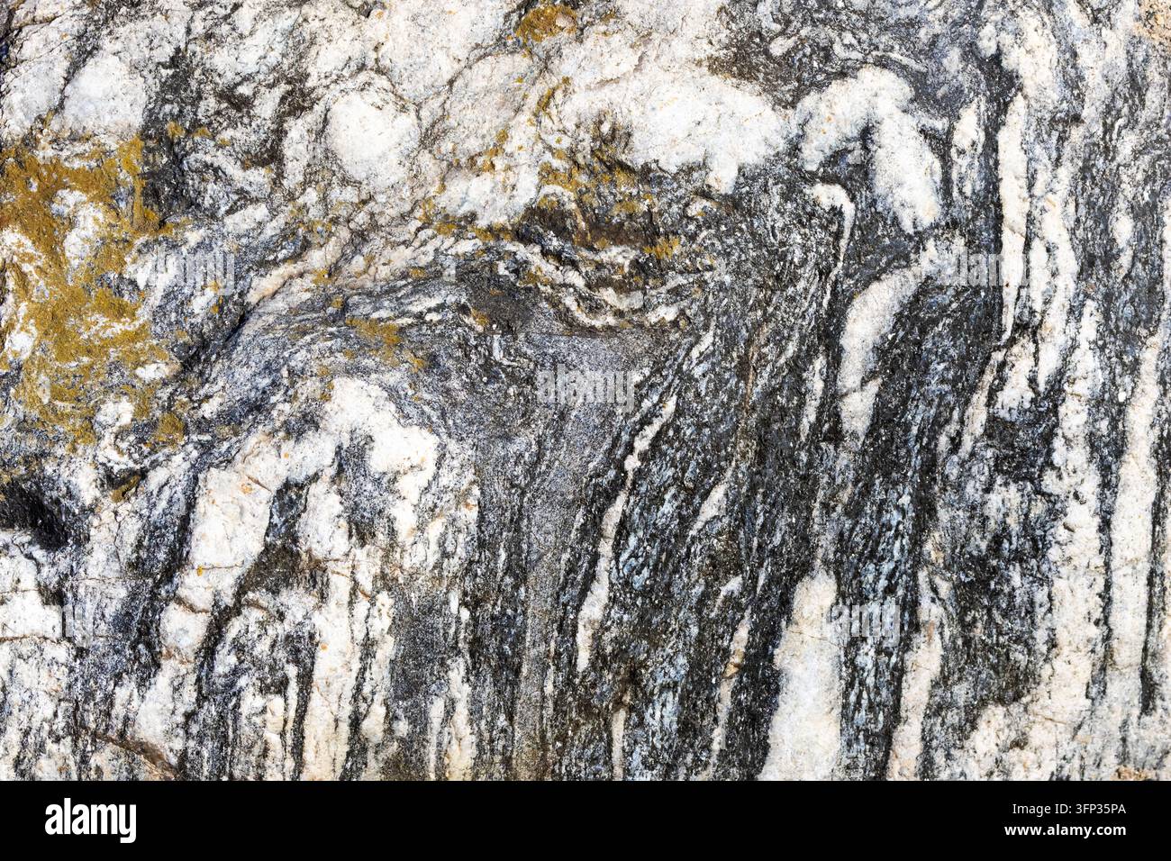 Natural stone with dark, white, and golden grey swirling patterns Stock Photo