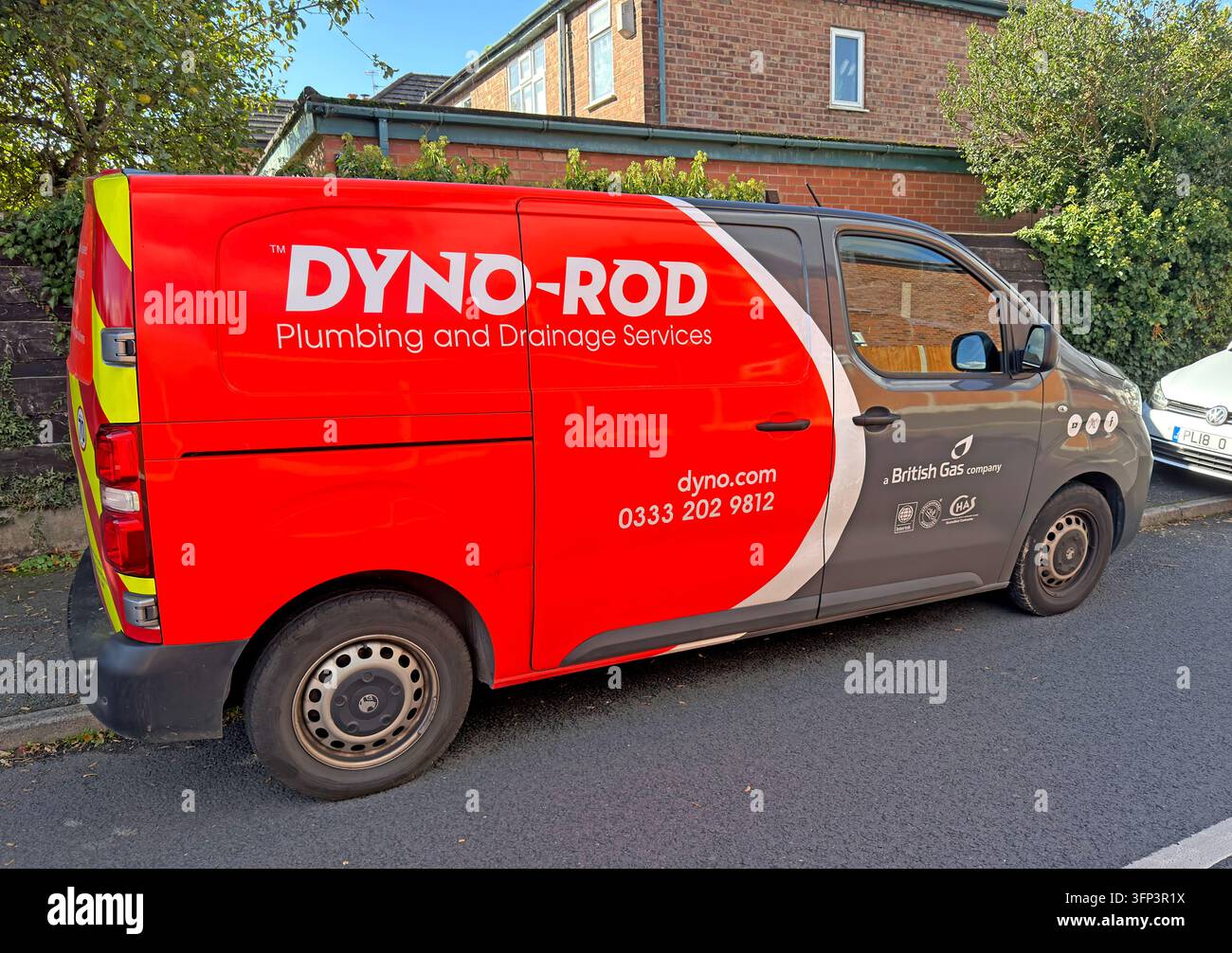 A red and grey Dyno-Rod service van has prominent drainage and plumbing branding and telephone contact details. Stock Photo