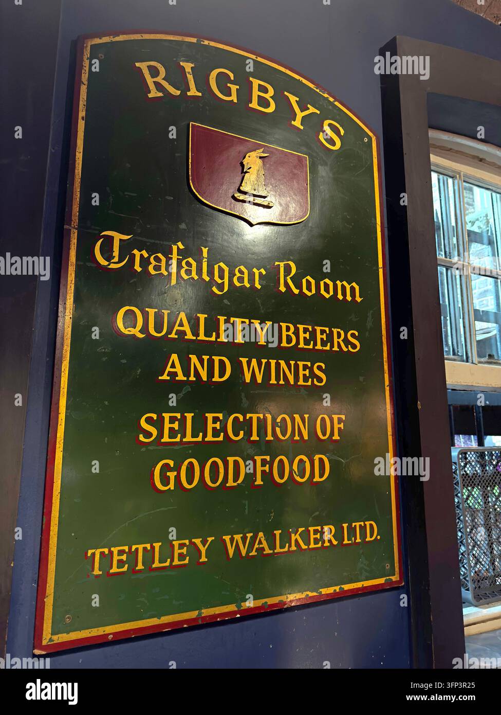 A traditional painted Rigby's pub sign advertises a Trafalgar Room, quality beers, wine, food and Tetley Walker Ltd. Stock Photo