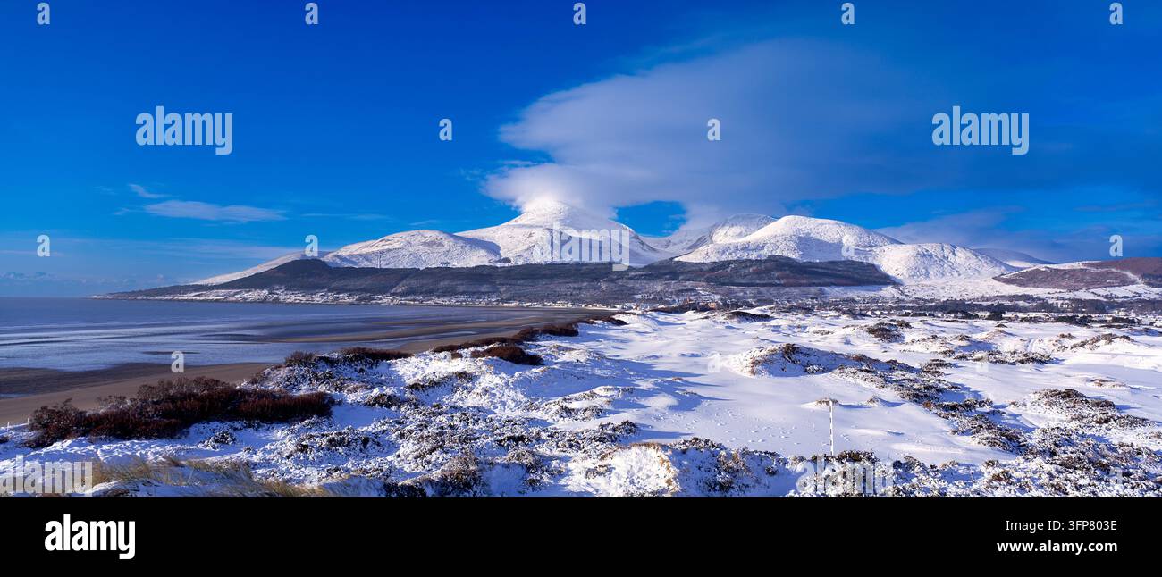 Snow covers Royal County Down Golf Club and the Mourne Mountains in County Down, Northern Ireland Stock Photo