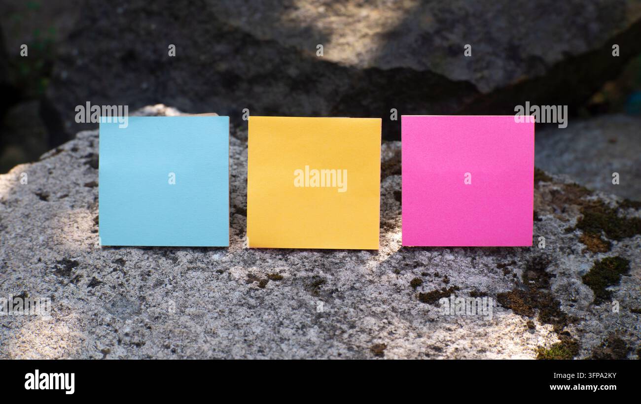Three Colorful Sticky Notes on Natural Stone Stock Photo