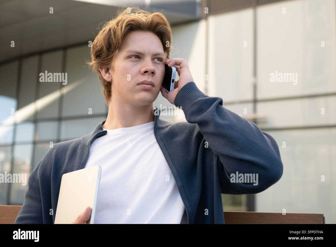 Young man making business call with laptop Stock Photo