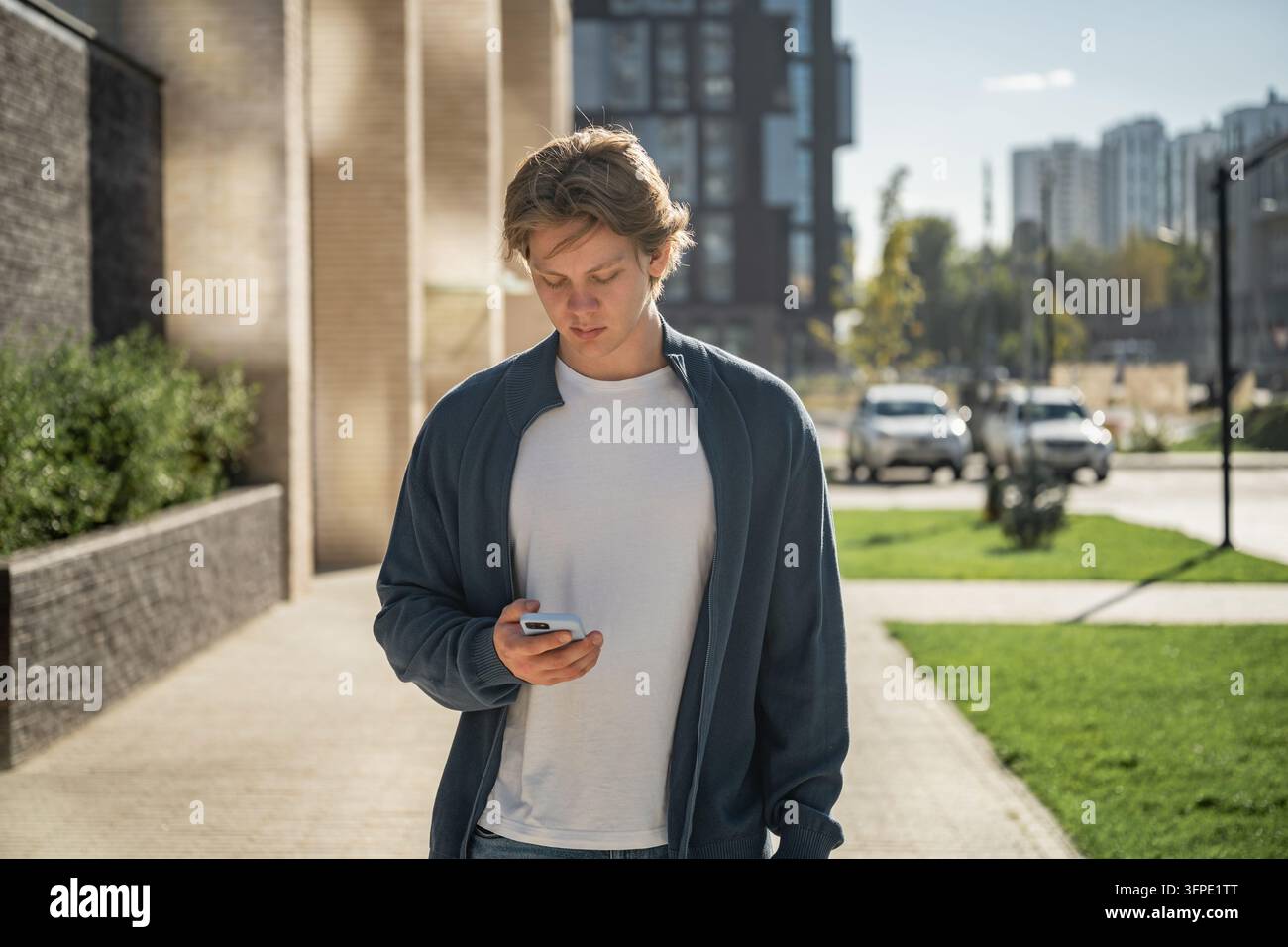 Young man using smartphone outdoors Stock Photo