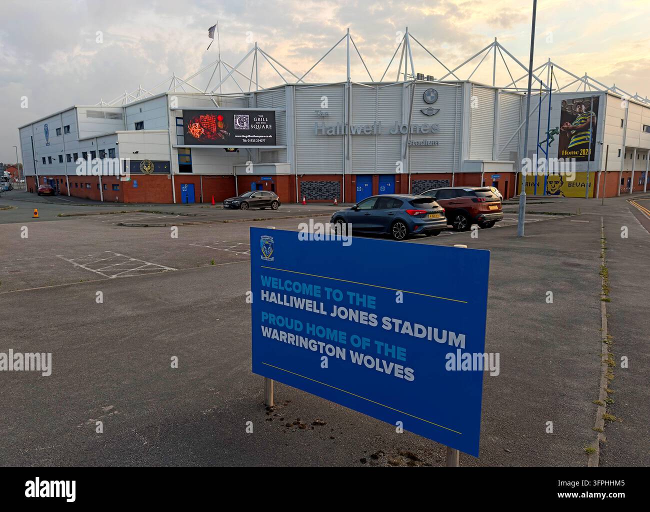 Warrington Wolves Halliwell Jones Stadium entrance and forecourt viewed across parking area Stock Photo