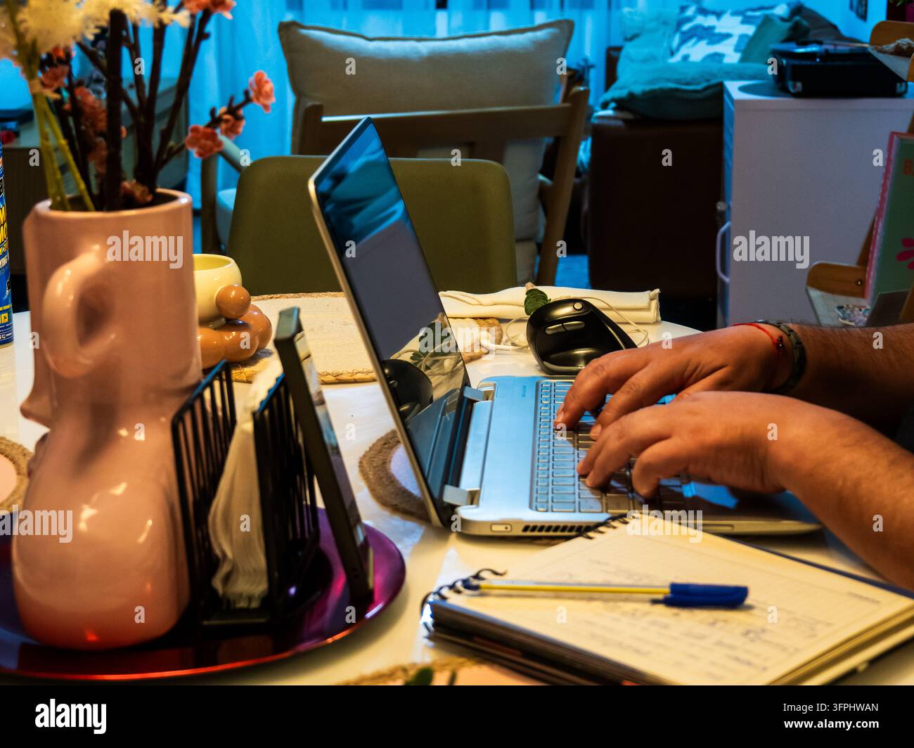 Comp Tabel Close-up view of a person working remotely at a dining table, using a ...