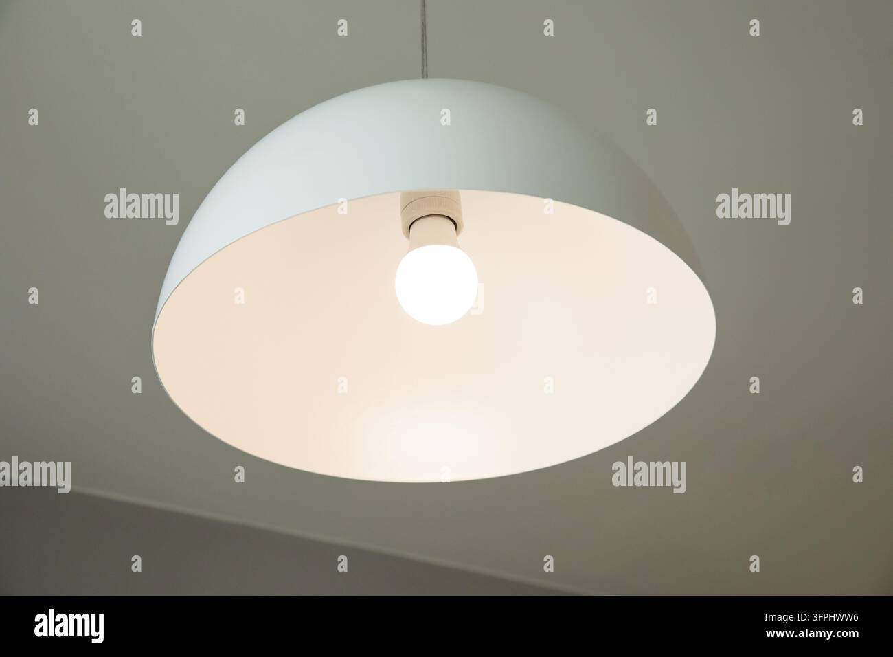 Ceiling lamp. Minimalist white ceiling lamp illuminating room with ...
