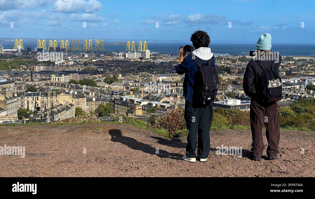 Enjoying the view from Calton Hill with offshore wind turbine foundation jackets under construction at Leith docks visible, Edinburgh Scotland - Smartphone Captured Stock Image