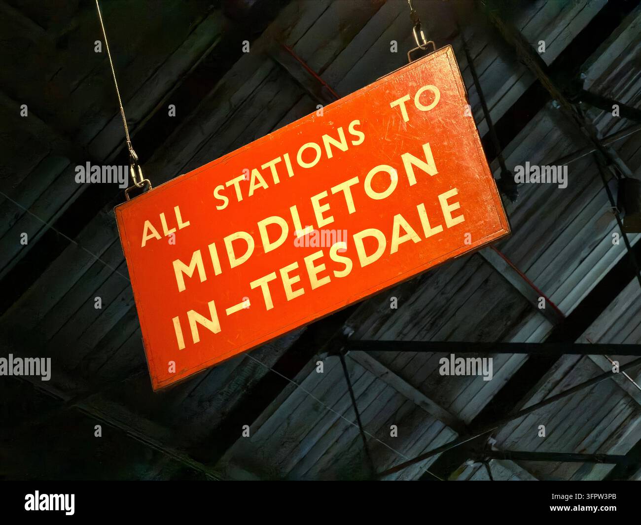A historic red railway destination board reads All Stations to Middleton-in-Teesdale in white lettering. Stock Photo