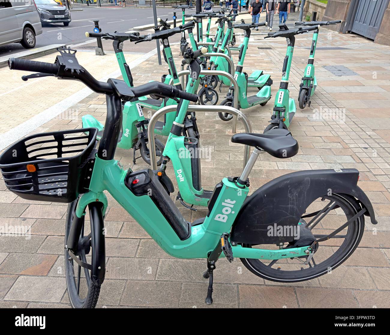 Turquoise Bolt-branded electric hire bicycles are parked in a marked cycle-sharing area on a Liverpool city-centre pavement. Stock Photo