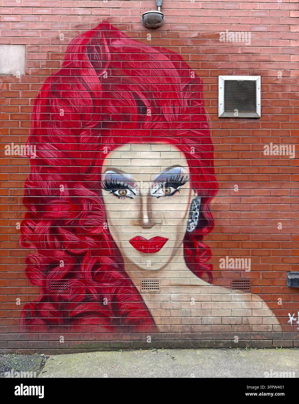 A large mural depicting drag performer Divina De Campo brightens a red-brick wall on Richmond Street in Manchester’s Gay Village. Stock Photo