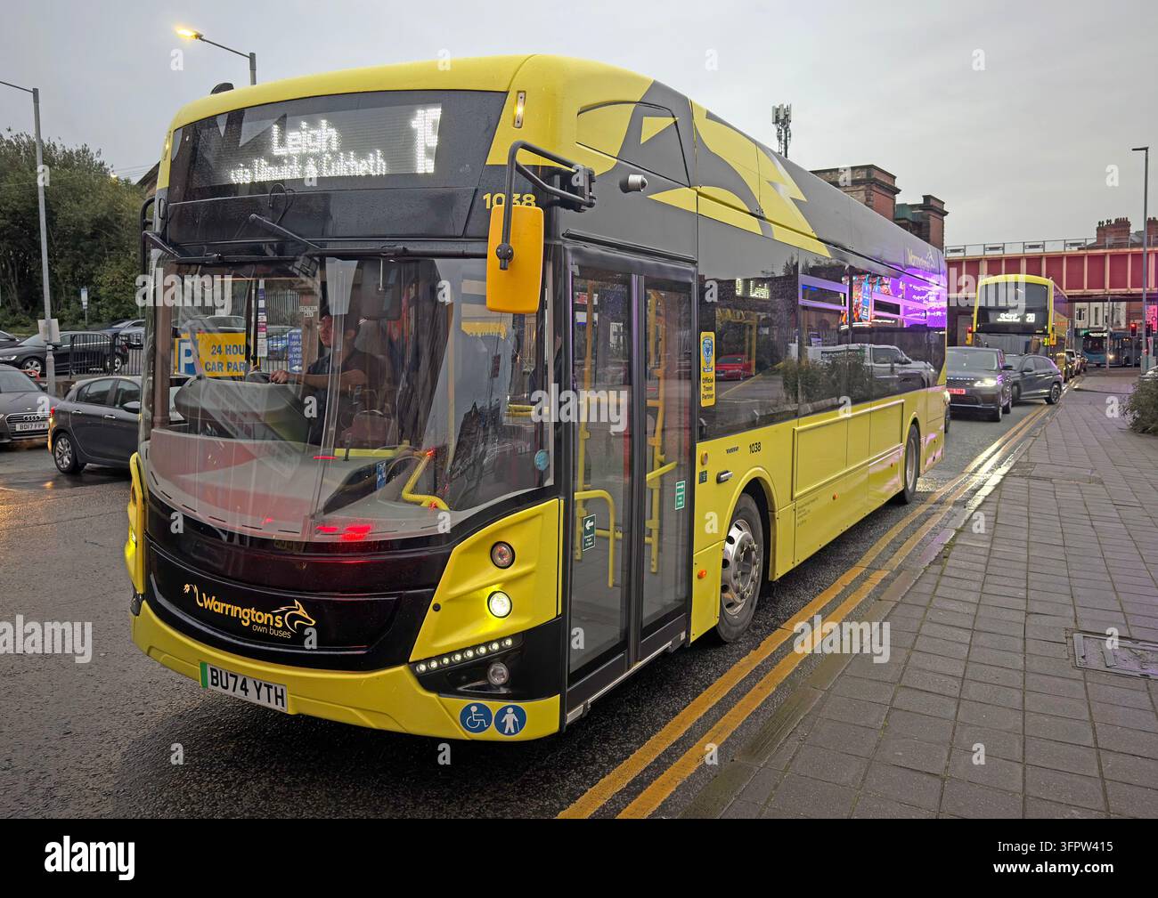 A Warrington’s Own Buses vehicle displays a Leigh-bound service 15 destination on Winwick Road during wet weather. Stock Photo