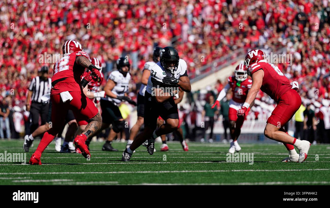 Michigan State's Jayden Savoury runs between Wisconsin defenders during ...